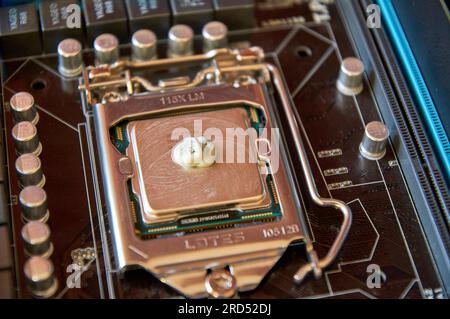 Applying thermal paste to the central processor of the motherboard close up Stock Photo