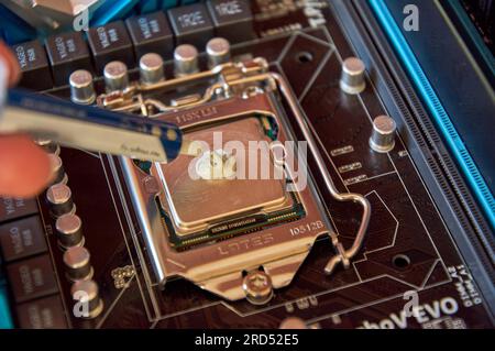 Applying thermal paste to the central processor of the motherboard close up Stock Photo