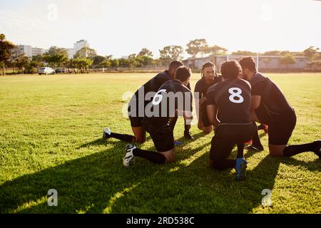 We have to win. Full length shot of a diverse group of sportsmen crouching together before playing rugby during the day. Stock Photo