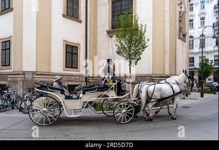Fiaker and street traffic at St. Peter's Square, St. Peter's Catholic Church, Vienna, Austria Stock Photo
