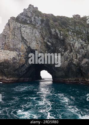Piercy Island, also known as 'The Hole In The Rock' (and by its Māori language name Motu Kōkako), Bay of Islands, New Zealand.