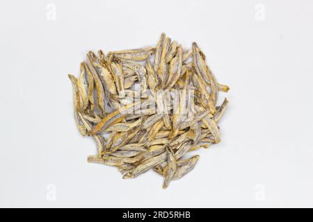 Dried anchovies on a white background. Isolated. Сlose-up. Top view. Small dried anchovies on salt on the table. Salted sea fish for beer. Seafood Stock Photo
