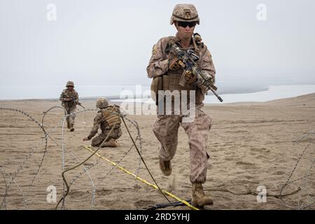 U.S. Marines with the 4th Combat Engineer Battalion, 4th Marine Division, and Peruvian marines from the Batallòn de Ingeniería de Infantería de Marina integrate as a single breaching team to conduct an in-stride mechanical breach during the execution of the combat engineers final exercise at the Salinas training range in support of Resolute Sentinel 23 in Peru, July 10, 2023. Resolute Sentinel improves readiness of U.S. and partner nation military and interagency personnel through joint defense interoperability training, engineering projects and knowledge exchanges to improve regional stabilit Stock Photo