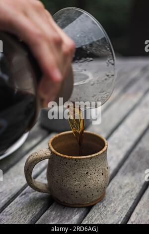 Close-up of male hand poring coffee into the cup from glass brewer Stock Photo