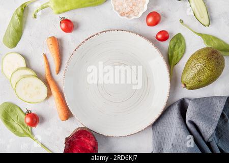 White plate in the center among vegetables and fruits close up.Vegan food, Keto, FODMAP, Paleo, Low-carb, plant-based diet, top view, copy space. Stock Photo