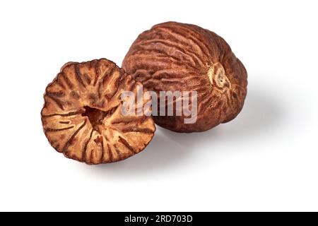 Two nutmegs, whole and half, isolated on white background. Stock Photo