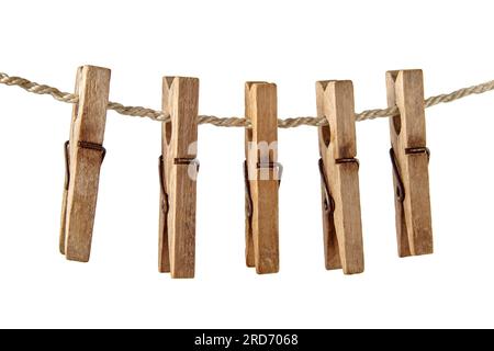 Wooden dilapidated clothespins on rope isolated on white background. Stock Photo