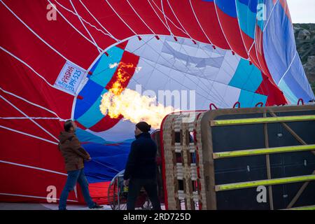 Balloonista firing up air balloon before start. Workers operators heating the air inside the balloon with the burner before balloon flight Cappadocia Stock Photo