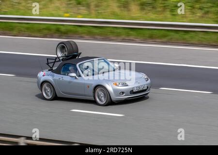 2008 Mazda Mx-5 Sport Silver Car Convertible Petrol 1999 cc, with Roadster Coupe Luggage Rack holding two tyres; travelling at speed on the M6 motorway in Greater Manchester, UK Stock Photo