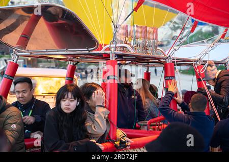 Tourists boarded in the passenger compartment basket of air balloon before the flight. Firing up the balloon before start in Cappadocia Turkey Stock Photo