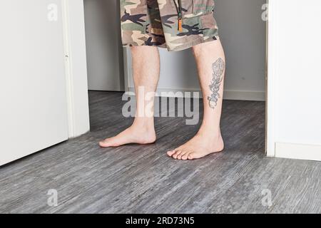 Man standing barefoot on floor Stock Photo