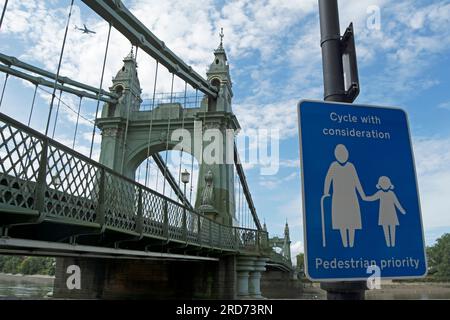 blue and white cycle with consideration, pedestrian priority sign adjacent to hammersmith bridge on the river thames in hammersmith, london, england Stock Photo