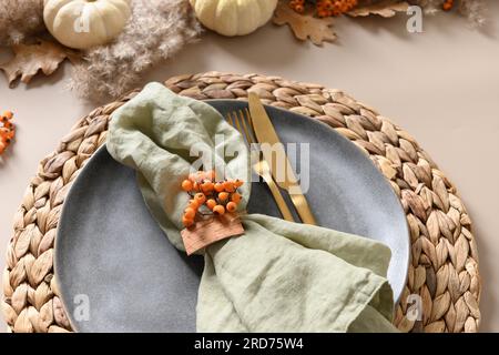 Thanksgiving day autumn table setting decoration in natural colors white pumpkins and orange berries on beige background. Close up. Stock Photo