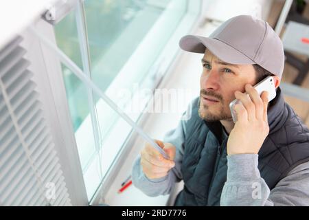 man installing cassette roller blinds on windows Stock Photo
