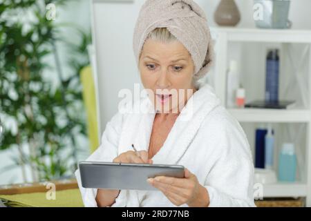 surprised senior woman looking at tablet Stock Photo