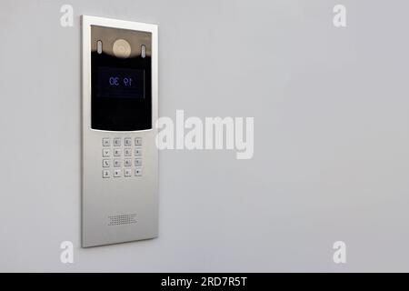 Doorbell with video camera and microphone, on the white wall of an apartment building, doorbell camera. Stock Photo