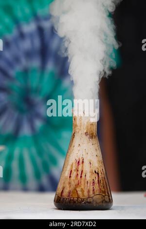 In a chemical flask, a substance reacts and smoke comes out. Stock Photo