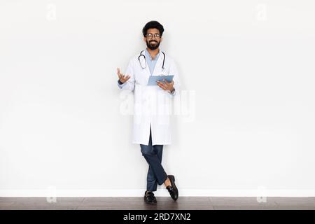 Friendly young middle eastern doctor posing on white background Stock Photo
