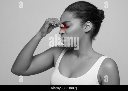 Sad black woman holding her nose because sinus pain Stock Photo