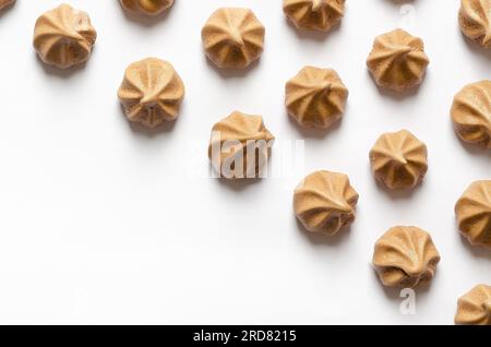 Mini chocolate meringue cookies on white background with copy space. Stock Photo