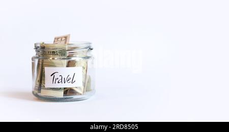 Piggy bank with dollars for travel. Accumulation of financial concept. Glass jar with money on a white background. Copy space Stock Photo