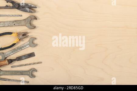 Flat lay composition with old tools on a light wooden background. Top view with various repair tools. The concept of craftsmanship and handicraft, fat Stock Photo