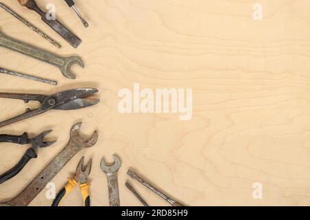 Flat lay composition with old tools on a light wooden background. Top view with various repair tools. The concept of craftsmanship and handicraft, fat Stock Photo