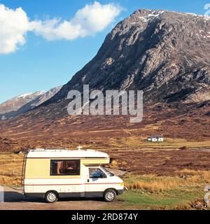 Historical 1996 side view of Volkswagen Auto Sleeper family Clubman camper van at foot of Stob Dearg mountain landscape on a blue sky spring sunny day touring Scottish Highlands in 1990s with white distant Lagangarbh Hut equipped with home comforts in accommodation available for hire and managed by the Scottish Mountaineering Club in Glen Coe Lochaber Highlands Scotland UK Stock Photo