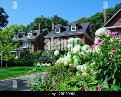 Residential street and house with colorful flowers in front yard Stock Photo