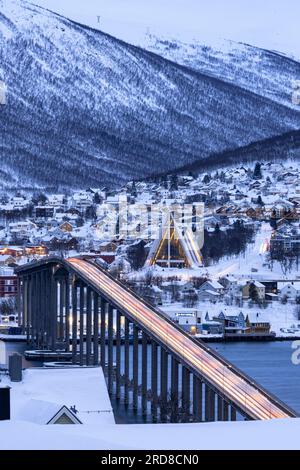 Dusk over the illuminated Bruvegen Bridge and Arctic Cathedral in winter, Tromso, Norway, Scandinavia, Europe Stock Photo