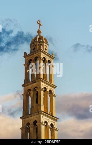 St. George Holy Orthodox Metropolitan Church bell tower and cross against a sky with clouds in Nafplion, Peloponnese, Greece, Europe Stock Photo