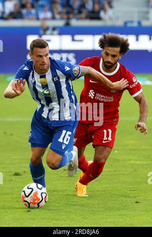 Karlsruhe, Germany. 19th July, 2023. Soccer: Test matches, Karlsruher SC - FC Liverpool: Karlsruhe's Philip Heise (l) and Liverpool's Mohamed Salah fight for the ball. Credit: Philipp von Ditfurth/dpa/Alamy Live News Stock Photo