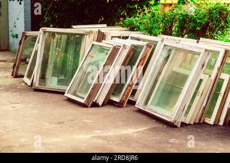Bunch of old wooden windows frames on the street. Replacement of windows, reconstruction. Stock Photo