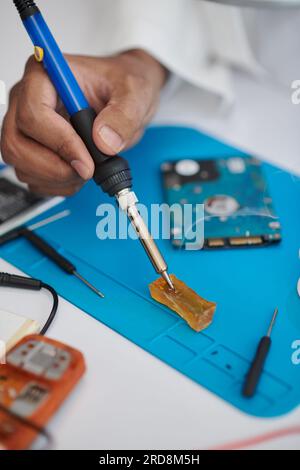 Closeup image of technician using rosin-based flux for electrical soldering Stock Photo