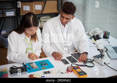 Team of technicians discussing better ways to repair gadgets of clients Stock Photo