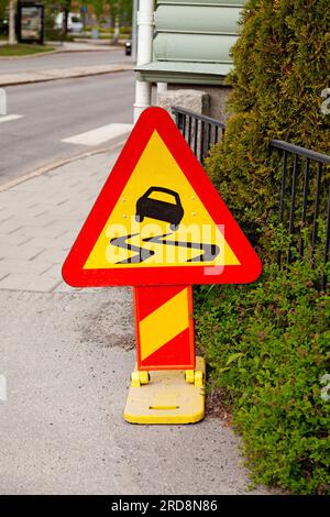 road sign warning of slippery road Stock Photo