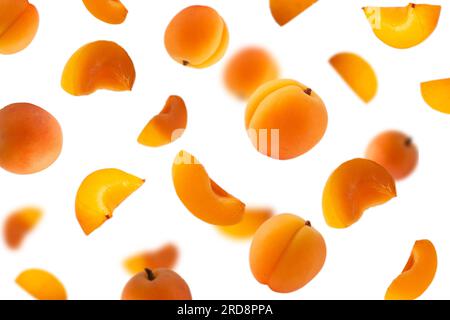 Falling apricots isolated on white. Background of apricot fruit. Sweet apricots isolated on white background cutout. With clipping path. Stock Photo