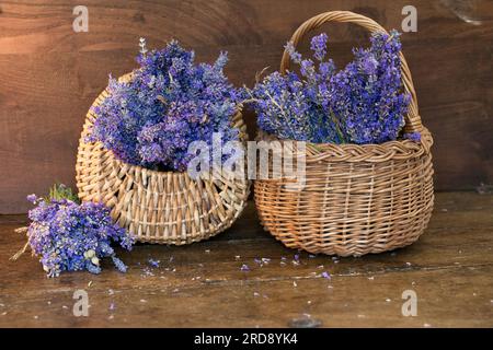 Fresh lavender (Lavandula angustifolia) in wicker baskets on a wood table Stock Photo