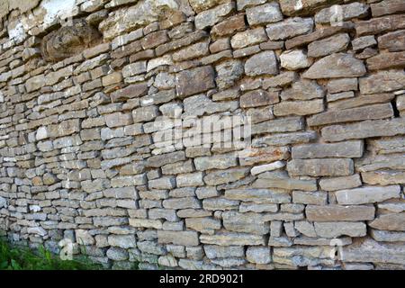 Old wall built of natural stone tiles Stock Photo