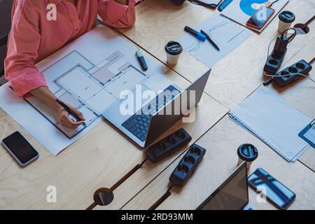 Close up of female architect engineer sketching a construction project with laptop at work place Stock Photo