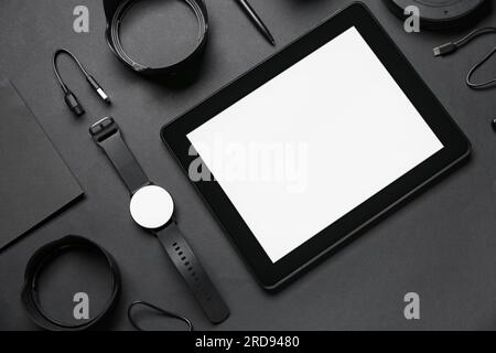 Set of modern gadgets with tablet computer on dark background Stock Photo