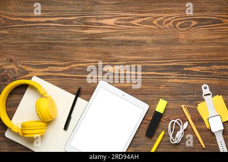 Composition with modern tablet computer, headphones, wristwatch and stationery on wooden background Stock Photo