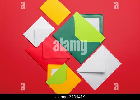 Composition with different envelopes and blank cards on red background Stock Photo