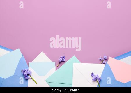Composition with different paper envelopes, blank cards and flowers on color background Stock Photo