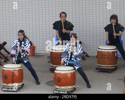 A group of Japanese drummers in traditional costume play their drums on the quayside at the port of Shimizu as a farewell for a visiting cruise ship. Stock Photo