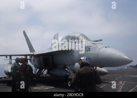 Sailors assigned to the 'Blacklions' of Strike Fighter Squadron (VFA) 213 prepare to chock and chain an F/A-18F Super Hornet attached to VFA-213 on the worldÕs largest aircraft carrier USS Gerald R. FordÕs (CVN 78) flight deck, July 14, 2023. The Gerald R. Ford Carrier Strike Group is participating in Neptune Strike, a multiyear effort focused on harmonizing U.S. and NATO planning teams to transfer command and control of Allied naval and amphibious forces to STRIKFORNATO, to provide assurance, deterrence, and collective defense for the Alliance. (U.S. Navy photo by Mass Communication Specialis Stock Photo