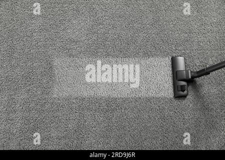 Vacuuming grey carpet. Clean area after using device, top view. Space for text Stock Photo