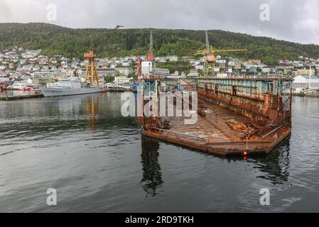 Norway Coast Guard offshore patrol vessel transferred to Norwegian navy as HNoMS Nordkapp (A531) & submersible floating drydock, dry dock, port cranes Stock Photo