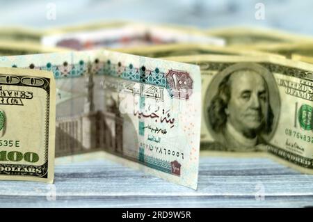 American and Egyptian money banknotes , pile of old vintage retro 100 One hundred American dollars bill with stack folded EGP Egyptian pounds LE, mone Stock Photo