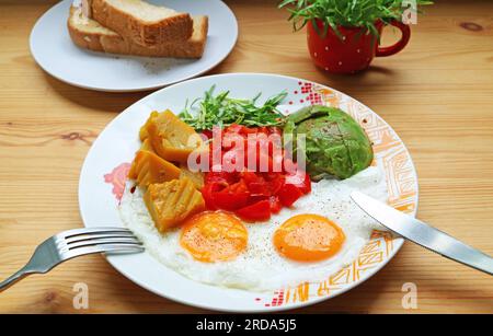 Healthy breakfast of a pair of sunny side up with colorful vegetable salad Stock Photo